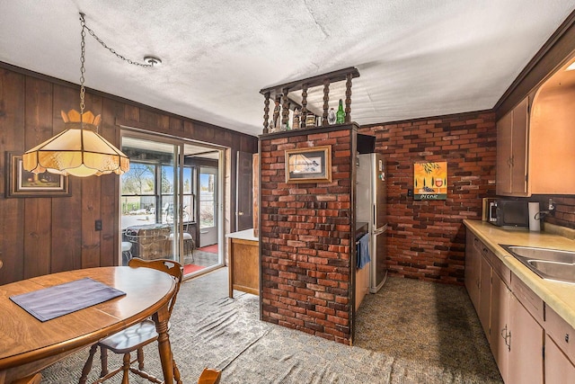 3500 N Oceana Dr, Hart, MI 49420 - kitchen featuring black microwave, light countertops, wood walls, and brick wall