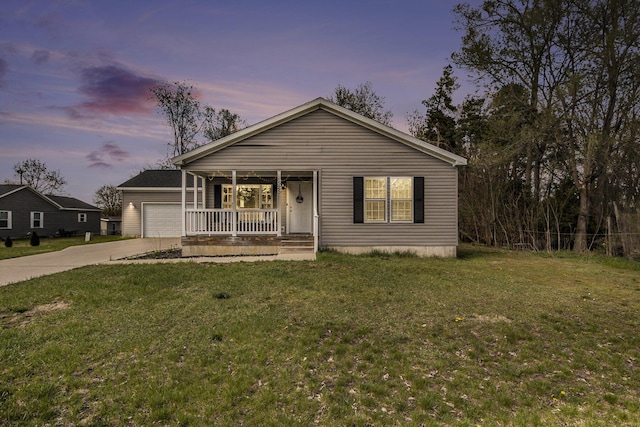 bungalow-style home with covered porch, a yard, concrete driveway, and a garage
