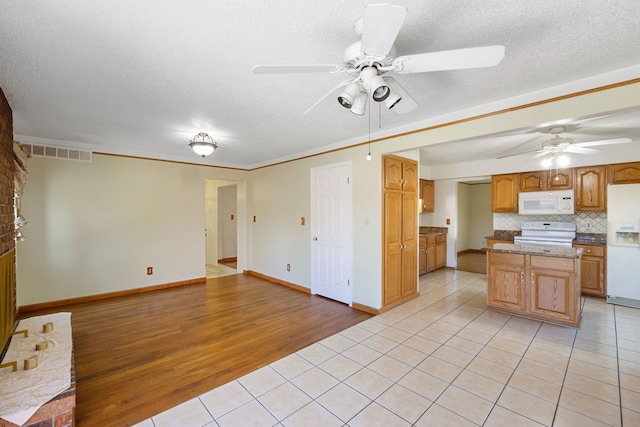 35490 Hatherly Dr, Sterling Heights, MI 48310 - kitchen with light tile patterned flooring, ceiling fan, white appliances, a center island, and visible vents
