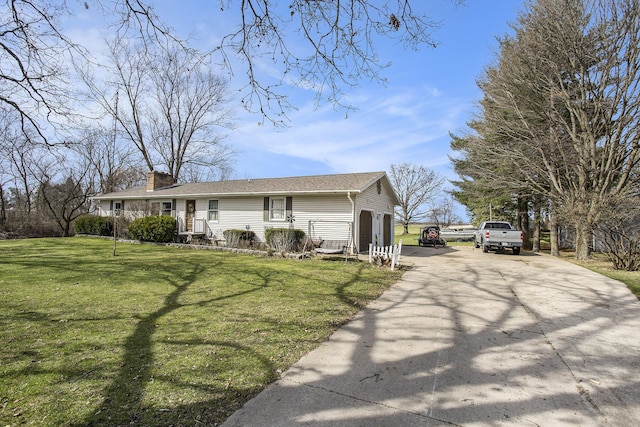 ranch-style home featuring driveway, a chimney, and a front lawn