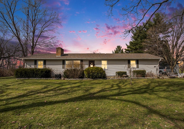 ranch-style house featuring a lawn and a chimney