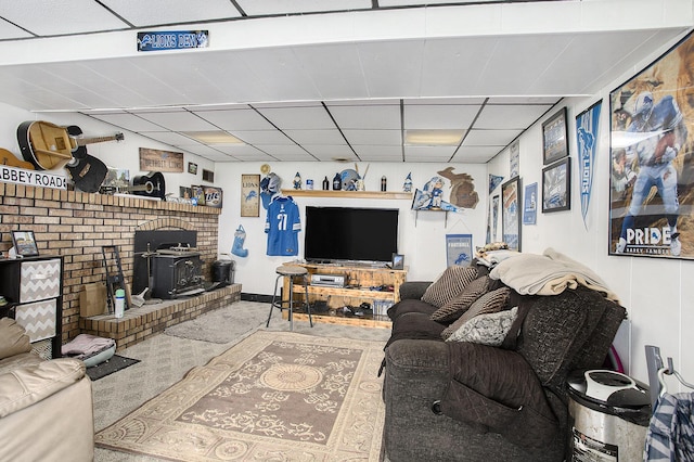 living room with a wood stove and a paneled ceiling