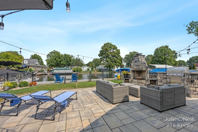 view of patio / terrace with a water view, an outdoor living space with a fireplace, fence, and area for grilling