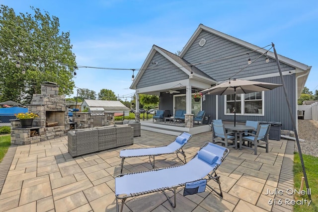 view of patio / terrace with fence, outdoor dining area, and an outdoor living space with a fireplace