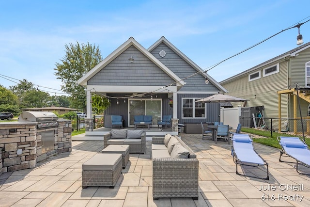 view of patio / terrace featuring an outdoor kitchen, fence, an outdoor living space, and a grill