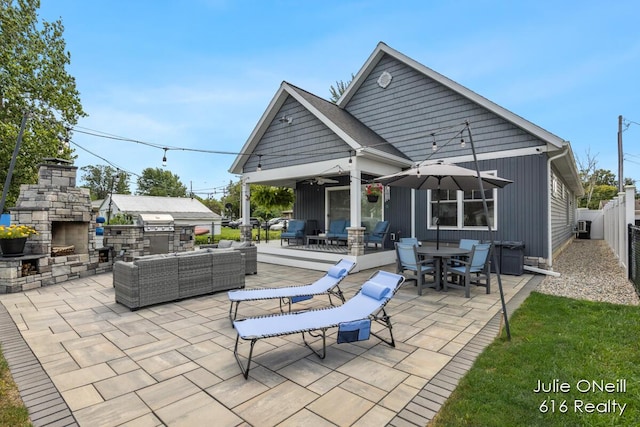 rear view of property with fence, exterior kitchen, outdoor lounge area, and a patio