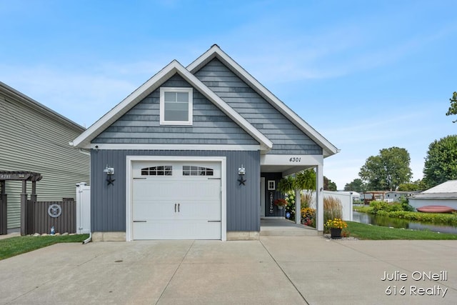 view of front of property with concrete driveway and a water view