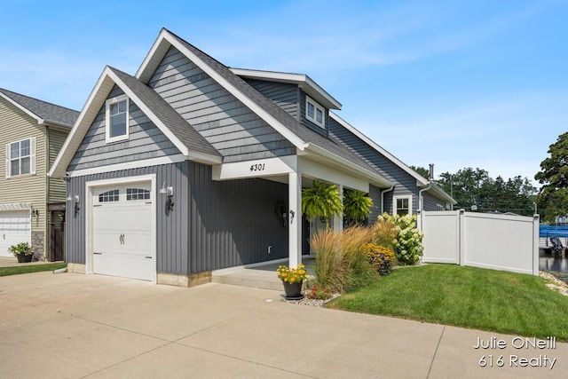 craftsman-style house featuring fence, driveway, roof with shingles, and a front lawn