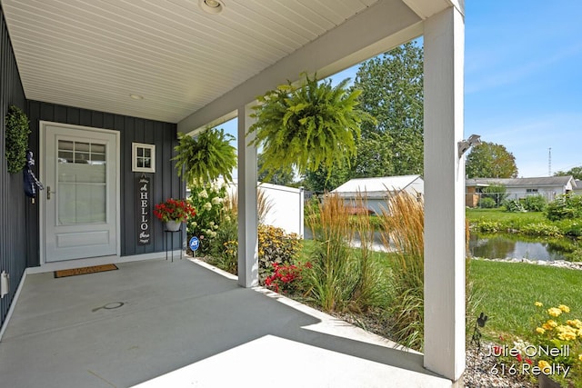 view of patio with a water view and a porch