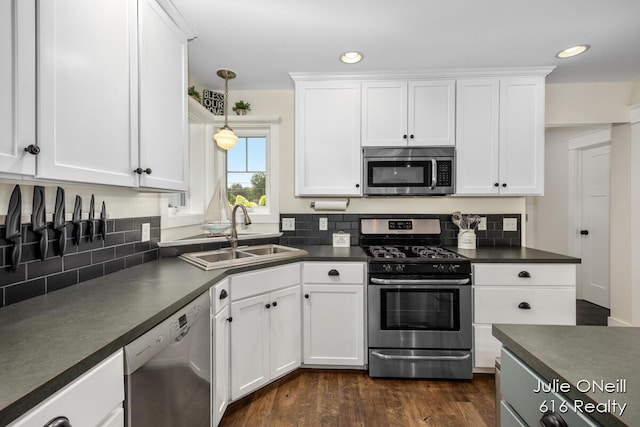 kitchen featuring a sink, white cabinetry, appliances with stainless steel finishes, and dark countertops
