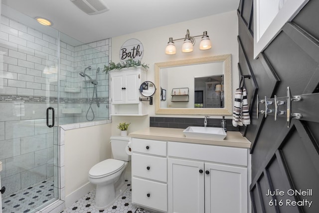 bathroom featuring vanity, a stall shower, toilet, and visible vents