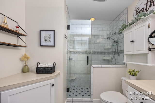 bathroom with vanity, a stall shower, and toilet