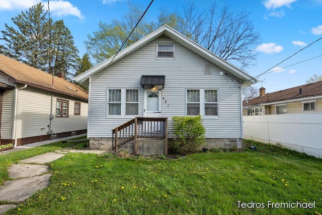 view of front of property featuring fence and a front lawn