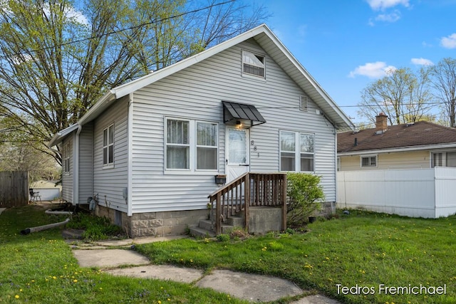 bungalow featuring fence and a front lawn