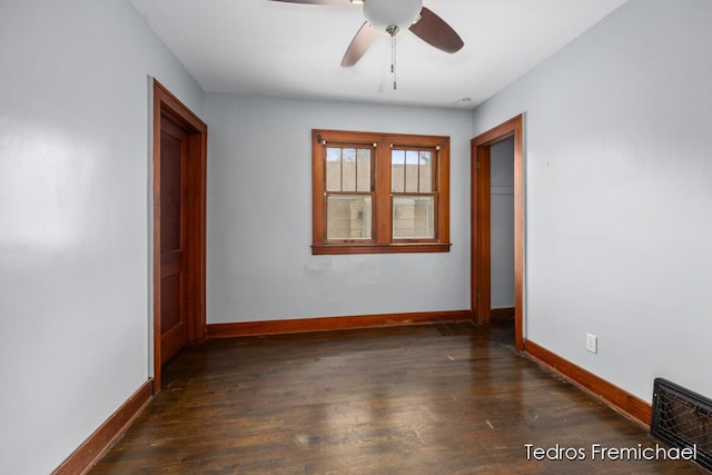 empty room featuring baseboards, a ceiling fan, dark wood finished floors, and visible vents