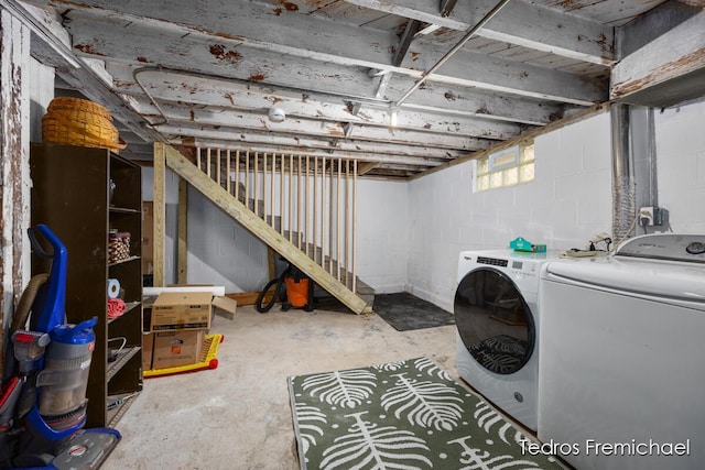 basement featuring concrete block wall and washing machine and dryer