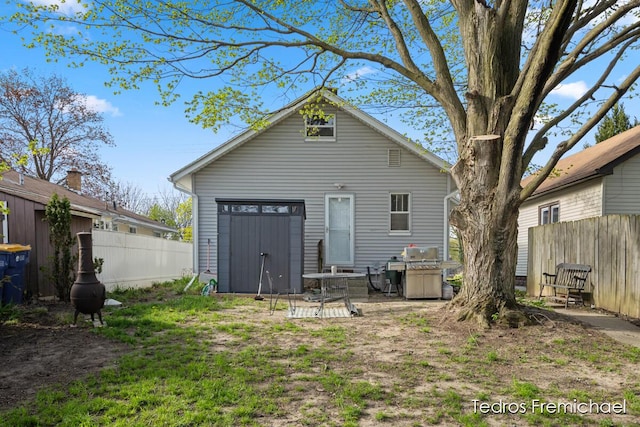 rear view of property featuring fence