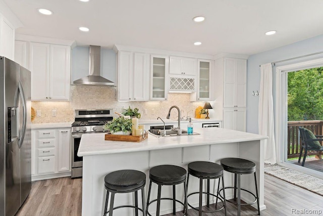 1319 Rochester Rd, Leonard, MI 48367 - kitchen featuring wall chimney exhaust hood, stainless steel appliances, a sink, light countertops, and white cabinets