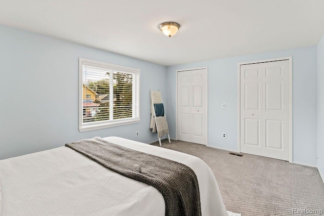 1319 Rochester Rd, Leonard, MI 48367 - bedroom featuring carpet floors, baseboards, and two closets