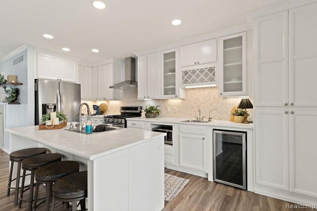 1319 Rochester Rd, Leonard, MI 48367 - kitchen with wall chimney range hood, stainless steel appliances, wine cooler, a sink, and recessed lighting