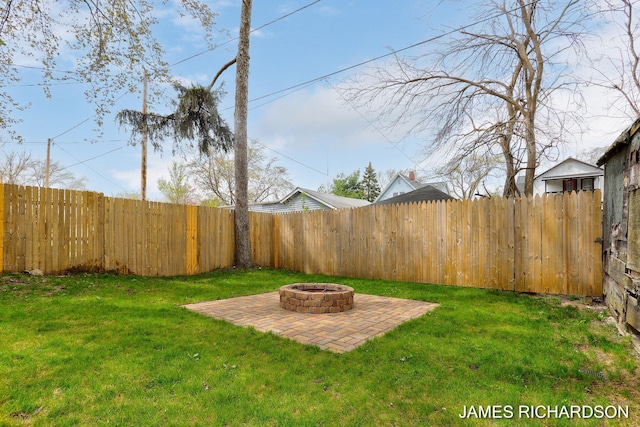 view of yard with a fire pit, a fenced backyard, and a patio area