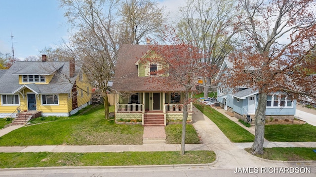 view of front of property with a porch, driveway, and a front yard