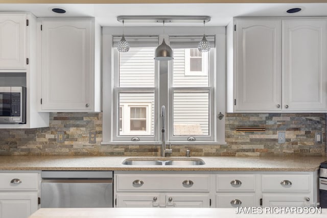 kitchen with a sink, stainless steel appliances, and white cabinetry