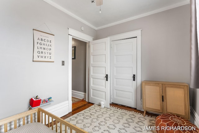 bedroom with ornamental molding and wood finished floors