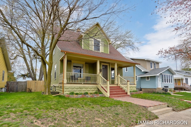 view of front of property with a porch, a shingled roof, a front lawn, and fence