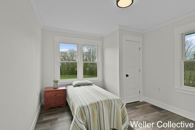 bedroom with baseboards, visible vents, multiple windows, and wood finished floors