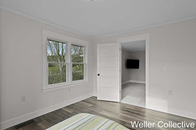 unfurnished room with baseboards, dark wood-style flooring, crown molding, and visible vents