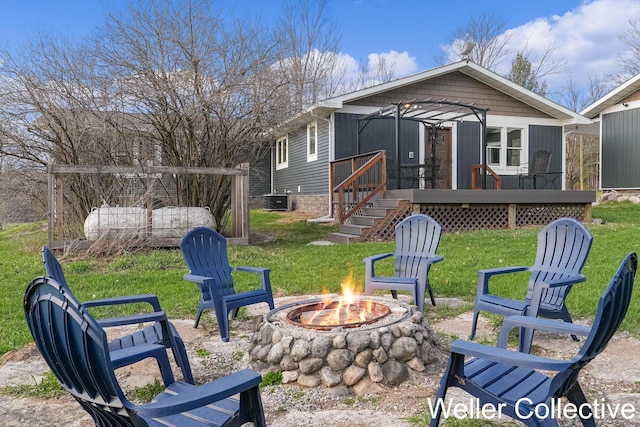 exterior space featuring a lawn, central air condition unit, an outdoor fire pit, and a deck
