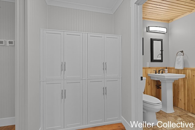 9090 E 32nd Rd, Cadillac, MI 49601 - bathroom with crown molding, wooden walls, a closet, a wainscoted wall, and wood ceiling