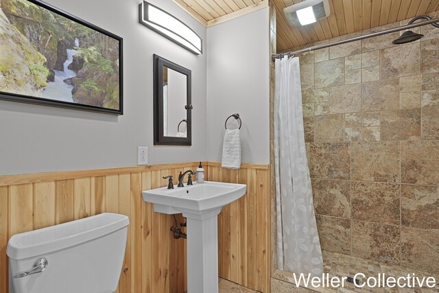 9090 E 32nd Rd, Cadillac, MI 49601 - bathroom with a wainscoted wall, a tile shower, wood ceiling, and wooden walls