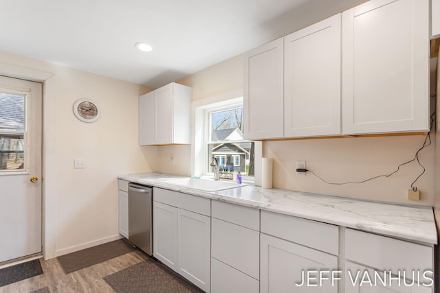kitchen with baseboards, white cabinetry, a sink, light wood-style flooring, and dishwasher