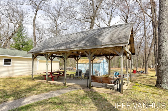 surrounding community featuring an outdoor structure, a patio, a shed, and a lawn