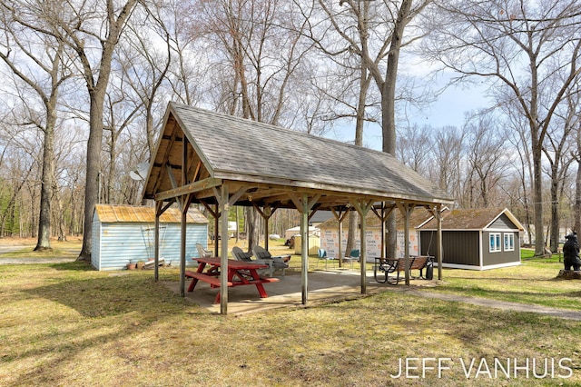 view of property's community with a yard, a shed, and an outbuilding
