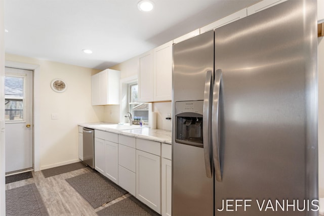 kitchen featuring plenty of natural light, a sink, wood finished floors, and stainless steel appliances