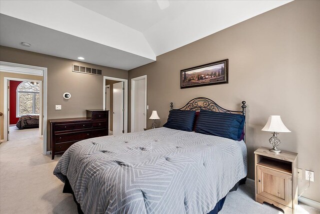 bedroom featuring light colored carpet, baseboards, visible vents, and lofted ceiling