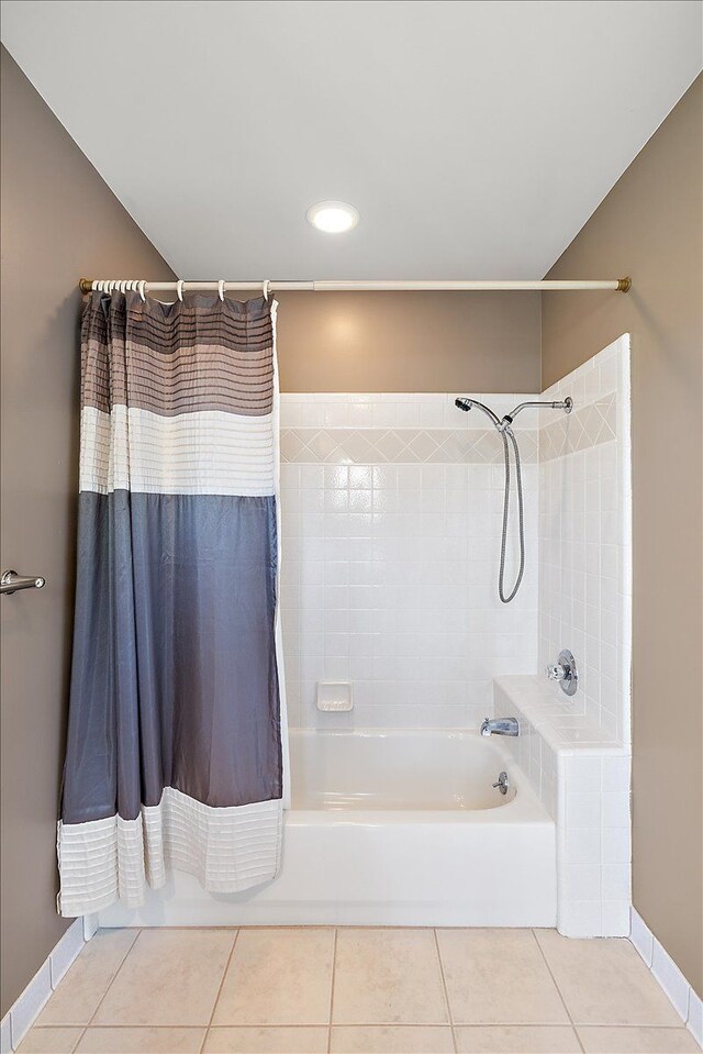 bathroom featuring tile patterned flooring, baseboards, and shower / bath combo with shower curtain