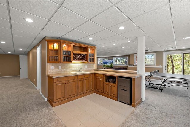 kitchen featuring light countertops, brown cabinetry, and light colored carpet