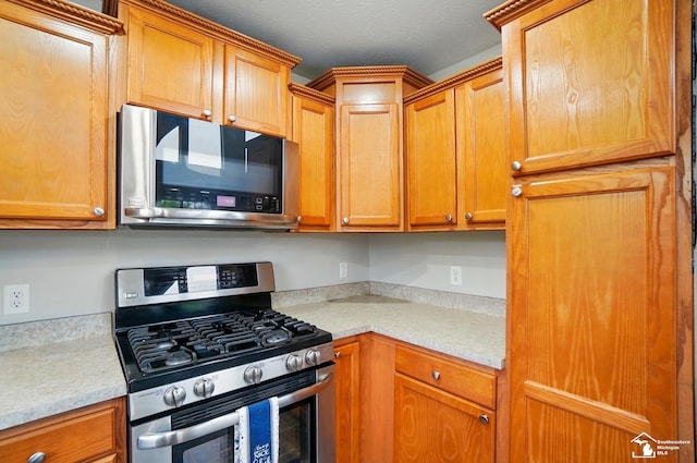 3325 Saint Anthony Rd, Temperance, MI 48182 - kitchen featuring stainless steel appliances, light countertops, and brown cabinets