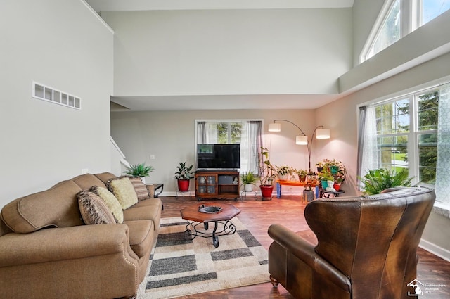 3325 Saint Anthony Rd, Temperance, MI 48182 - living room featuring a high ceiling, plenty of natural light, wood finished floors, and baseboards