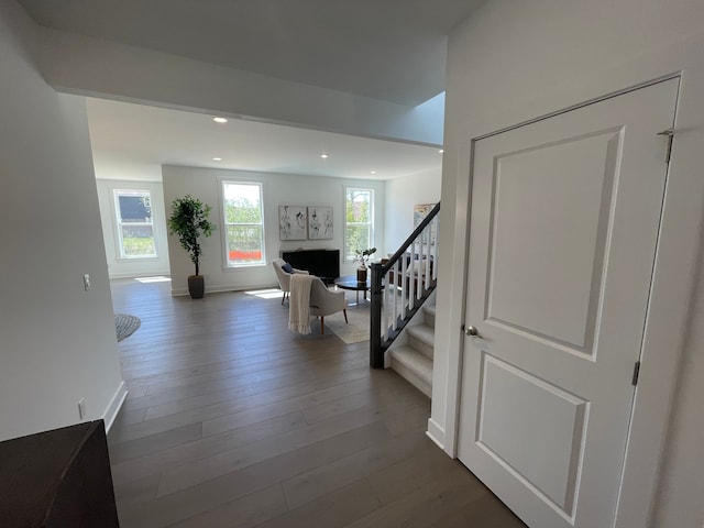 hall featuring recessed lighting, dark wood-style flooring, baseboards, and stairway