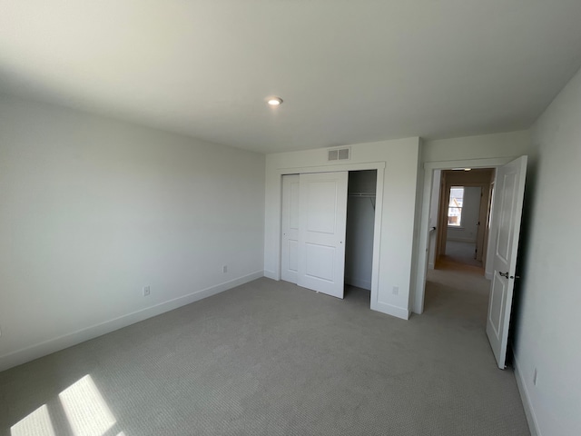 unfurnished bedroom with visible vents, a closet, baseboards, recessed lighting, and light colored carpet