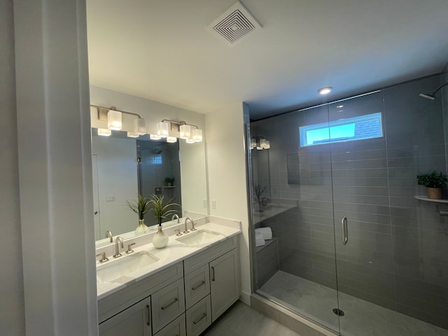 full bath featuring visible vents, a sink, double vanity, and a shower stall