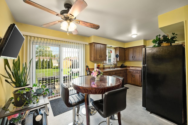 kitchen featuring freestanding refrigerator, a ceiling fan, and a sink