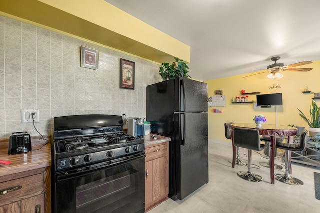 kitchen featuring black appliances, a ceiling fan, brown cabinetry, and backsplash