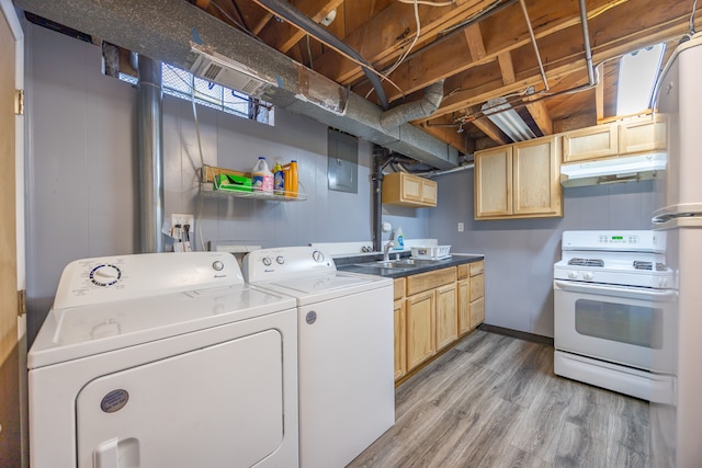 laundry area featuring independent washer and dryer, light wood-style flooring, electric panel, and baseboards