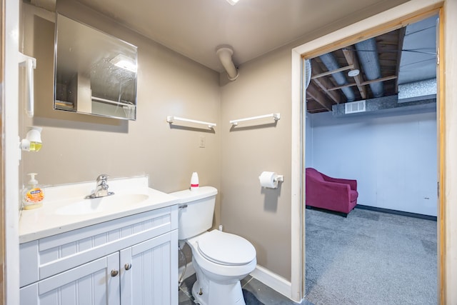 bathroom with toilet, vanity, and baseboards